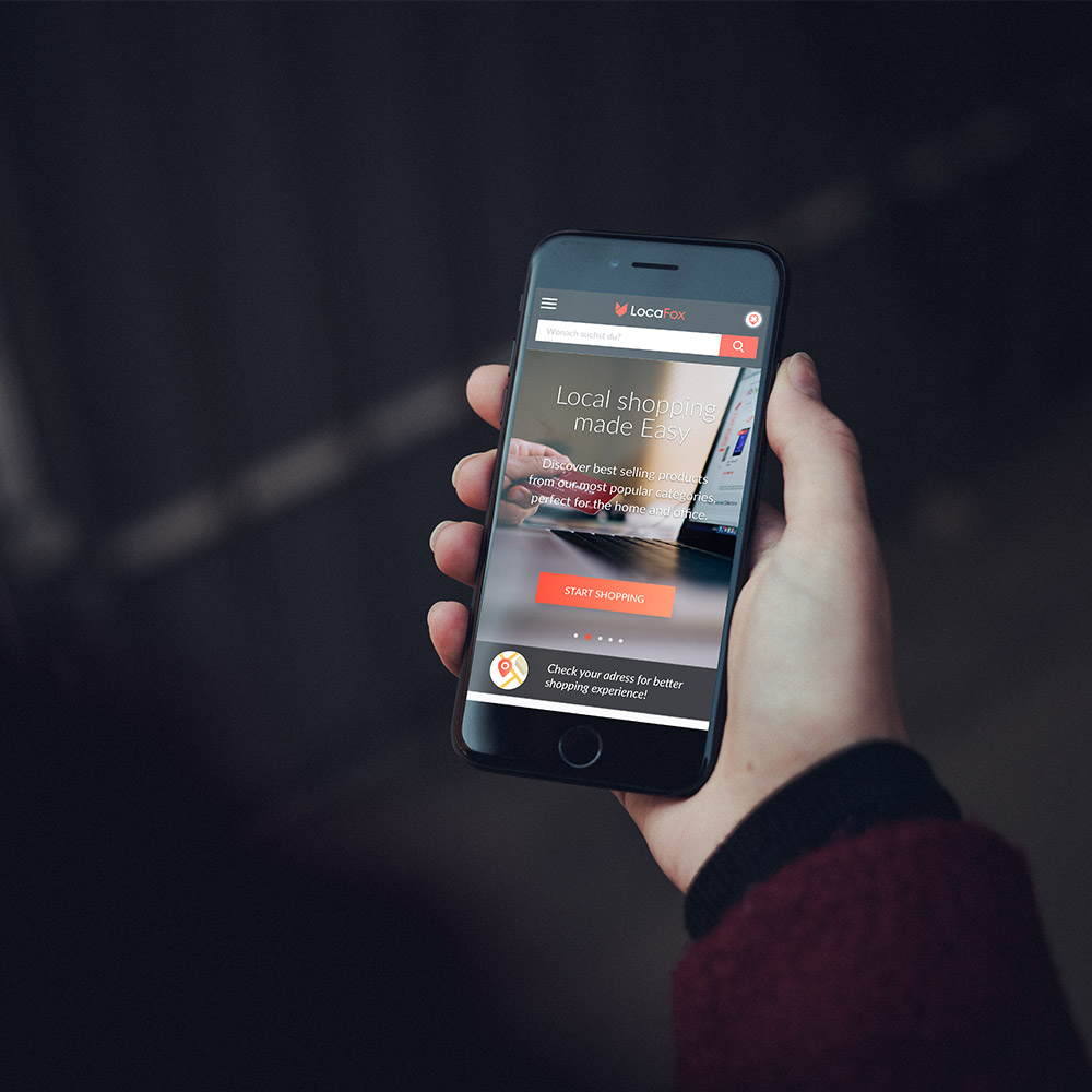 Person holding a phone showing Locafox home page